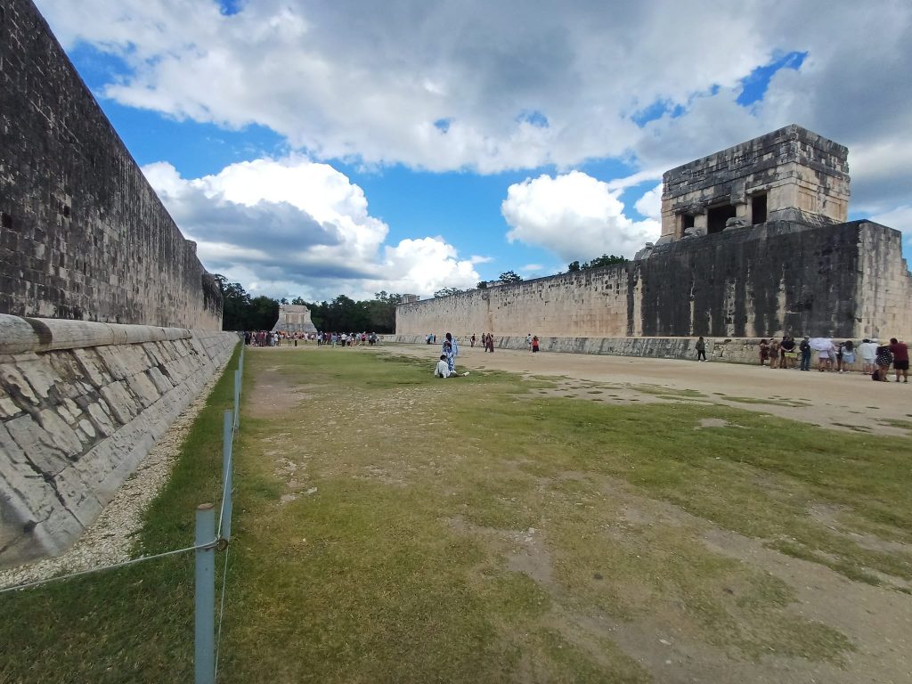 Panorámica del Gran Juego de Pelota en Chichén Itzá, con sus altos muros laterales, relieves tallados y visitantes recorriendo el sitio arqueológico. Visita de José Cotino a este lugar