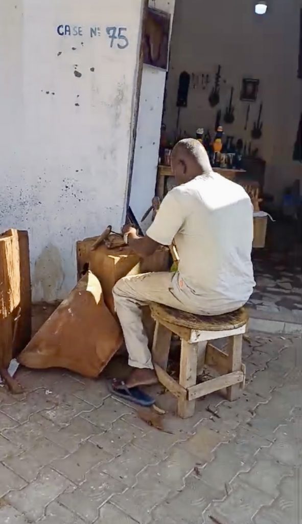 Artesano senegalés tallando figura de madera