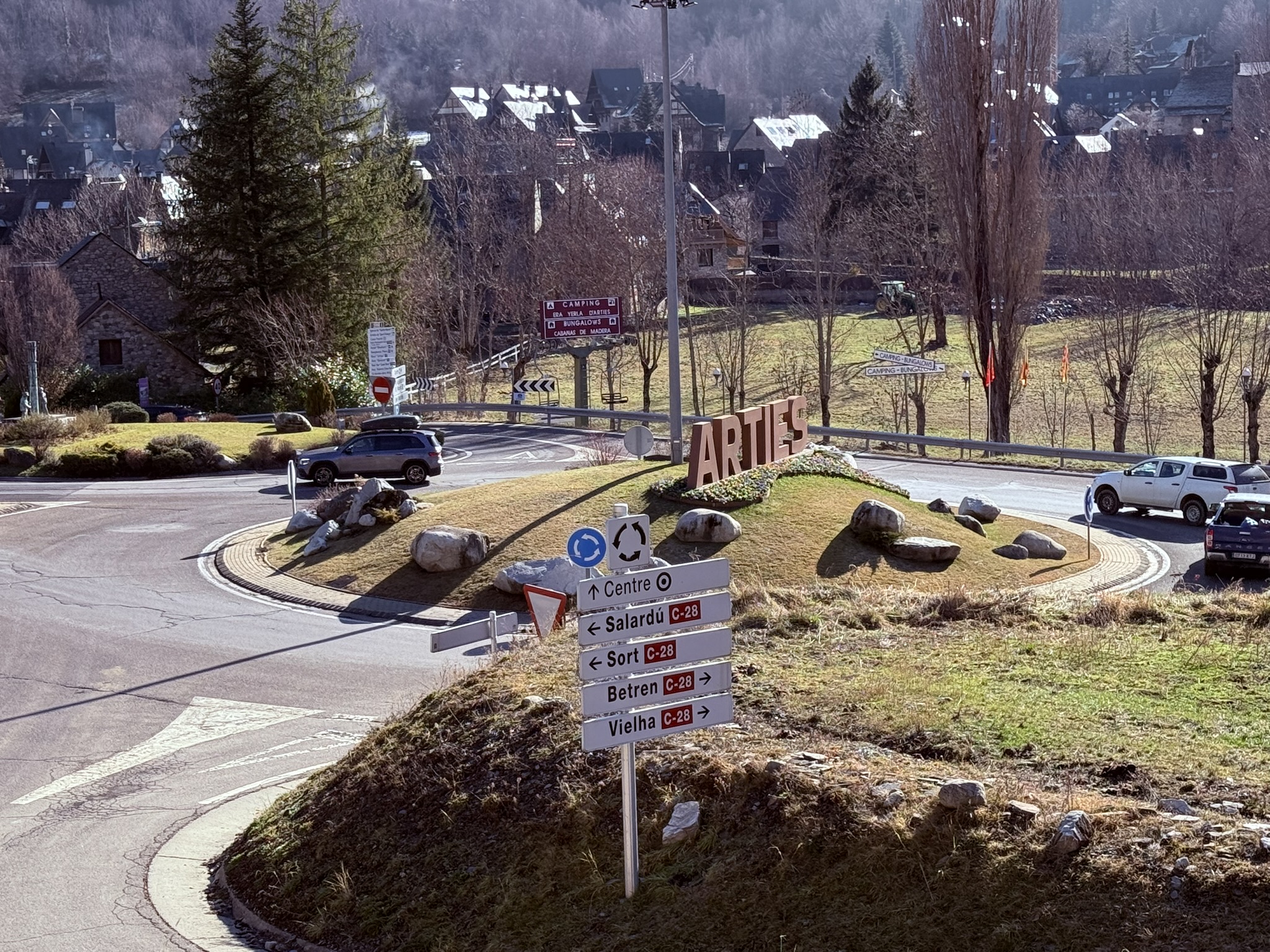 Cartel grande con las letras de Arties en la entrada del pueblo, en el Valle de Arán, rodeado de paisaje de montaña