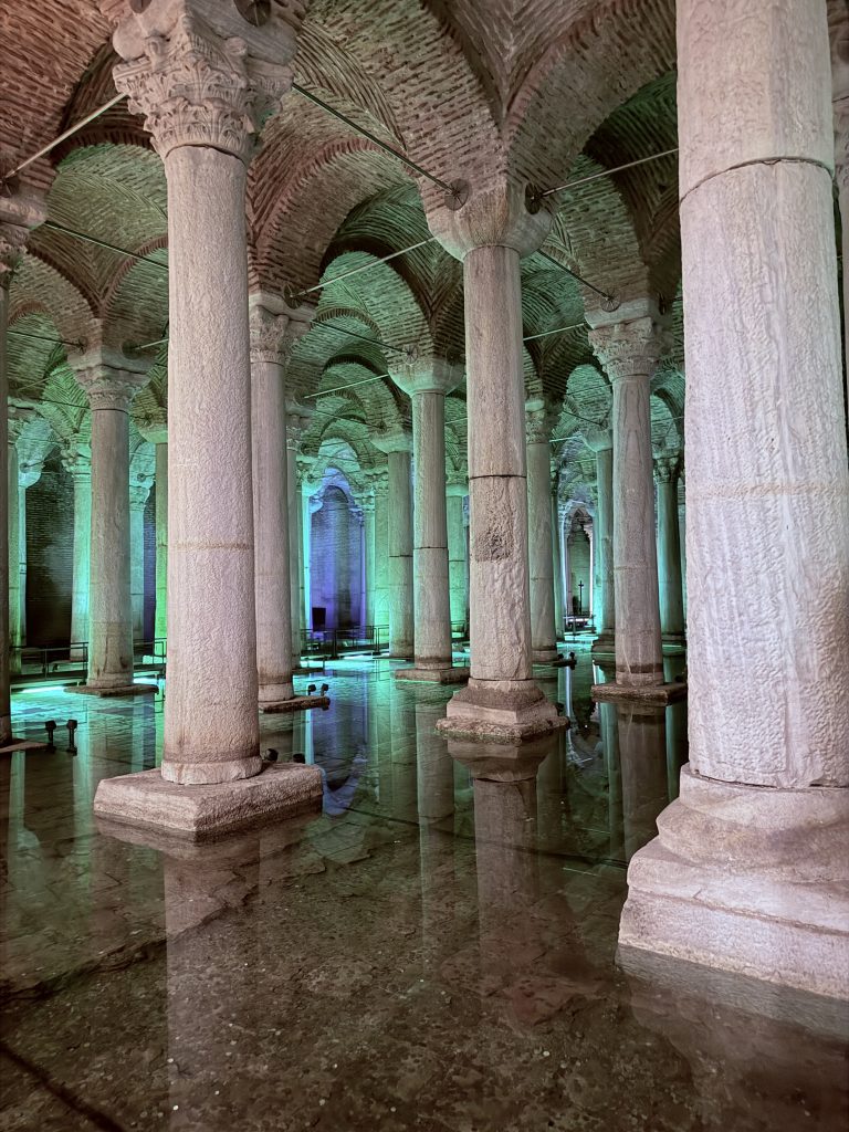 Columnas iluminadas en el interior de la Cisterna Basílica de Estambul reflejadas en el agua