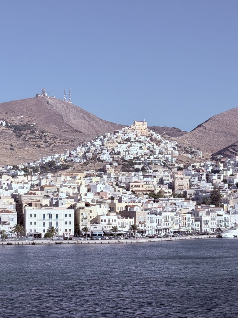 Vista panorámica de Ermúpoli en la isla de Siros, Grecia, con edificios neoclásicos junto al mar Egeo.