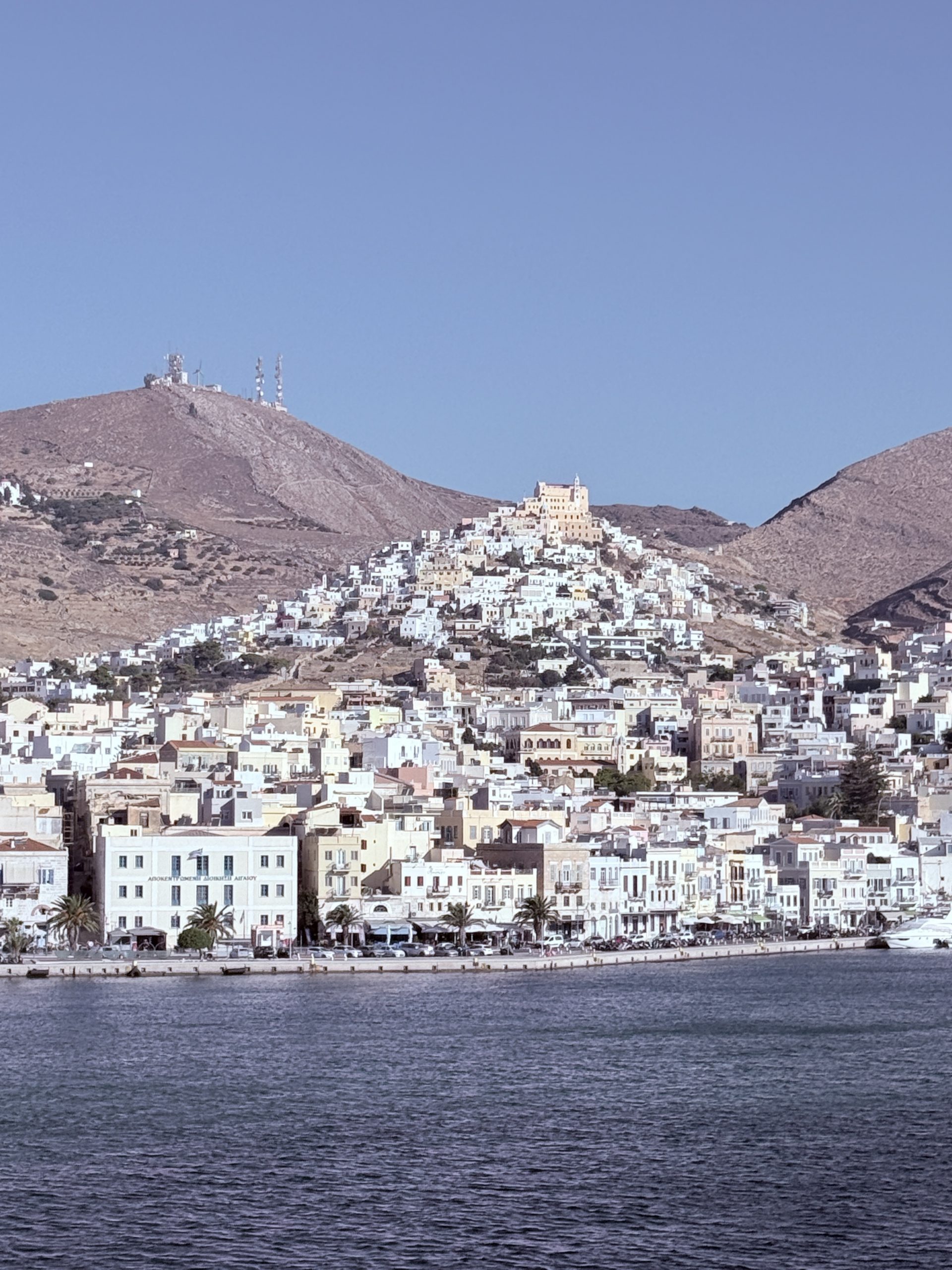 Vista panorámica de Ermúpoli en la isla de Siros, Grecia, con edificios neoclásicos junto al mar Egeo.