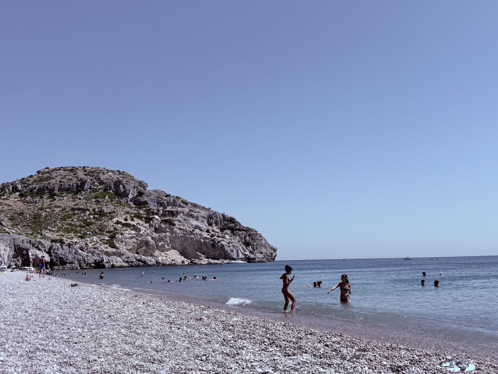 Playa Traounou en Rodas con aguas turquesas, arena amplia y formaciones rocosas al fondo