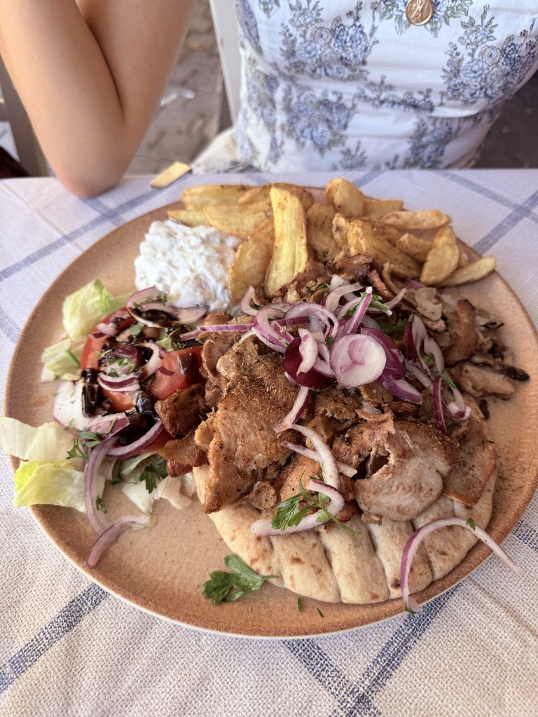 Gyros de pollo servido en plato con pan de pita, verduras frescas y salsa tradicional griega