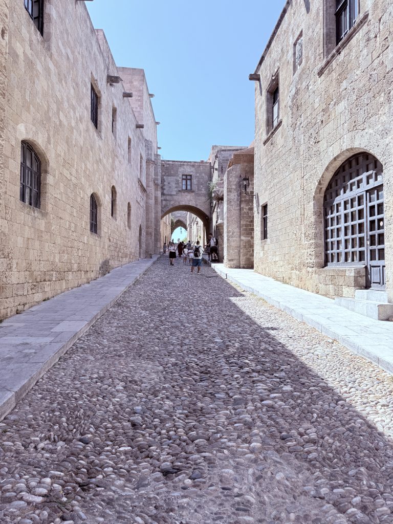 Vista de la Calle de los Caballeros en Rodas, una calle medieval empedrada con fachadas de piedra y arquitectura histórica