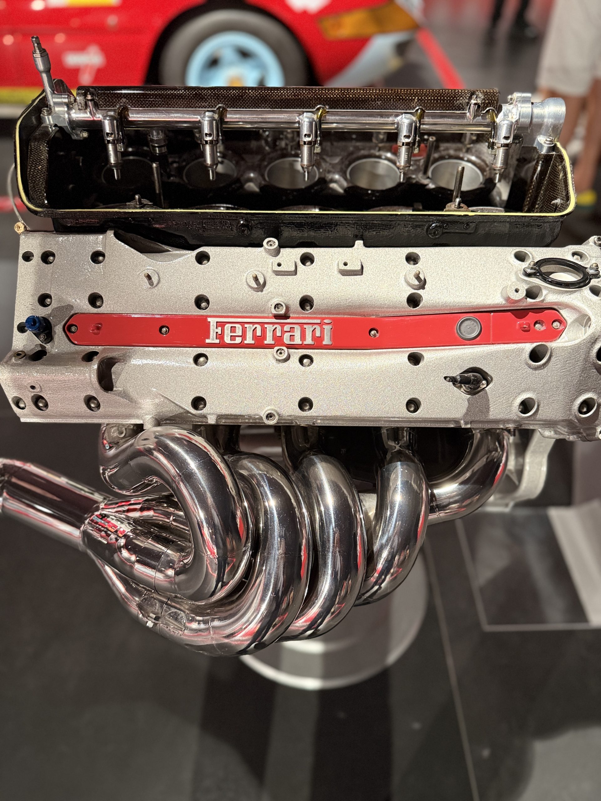 Motor Ferrari expuesto en el Museo Ferrari de Maranello, mostrando sus componentes mecánicos en detalle