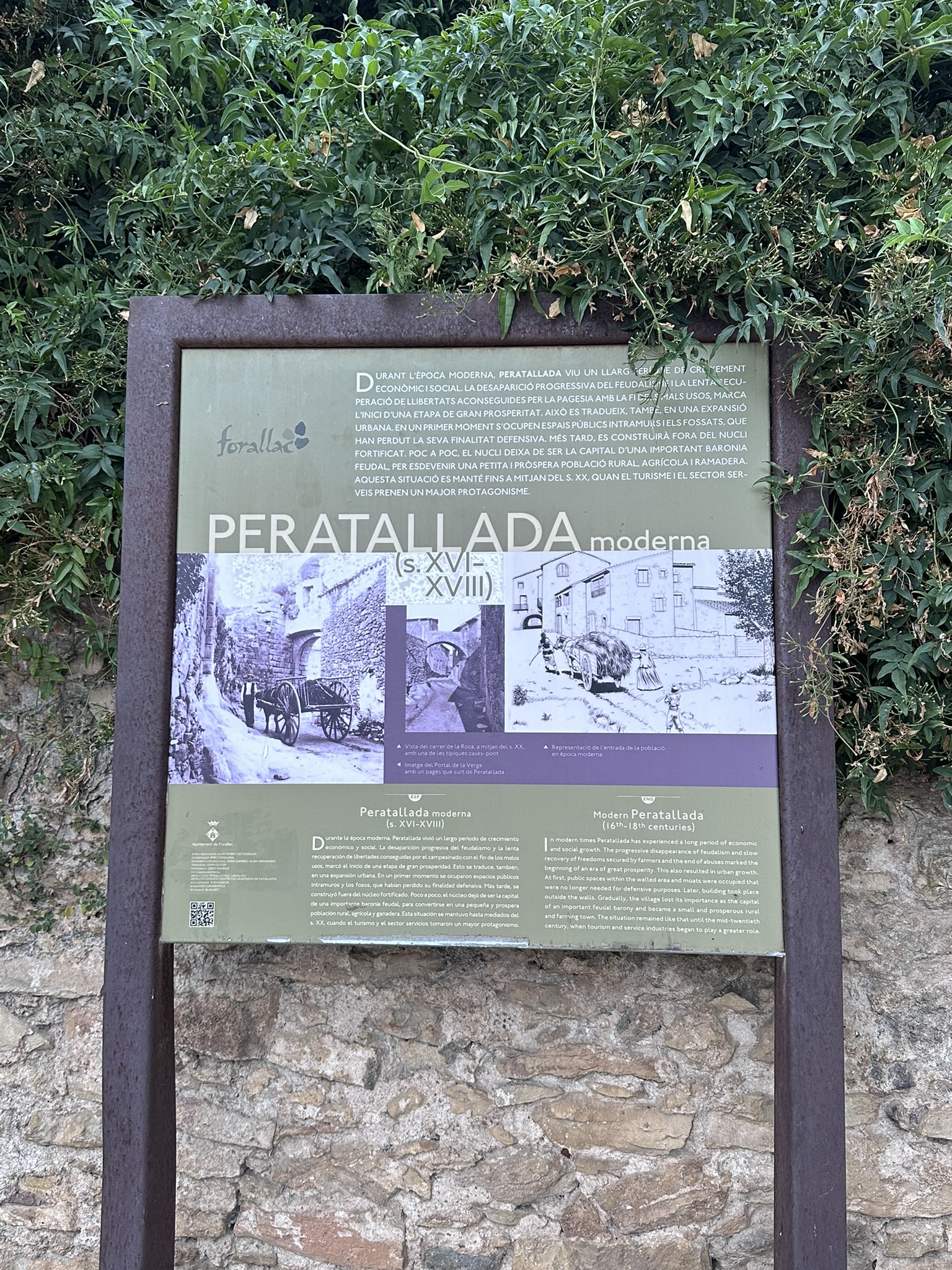 Cartel turístico en la entrada de Peratallada que ofrece una introducción histórica al pueblo medieval, ubicado en el Baix Empordà, Girona.