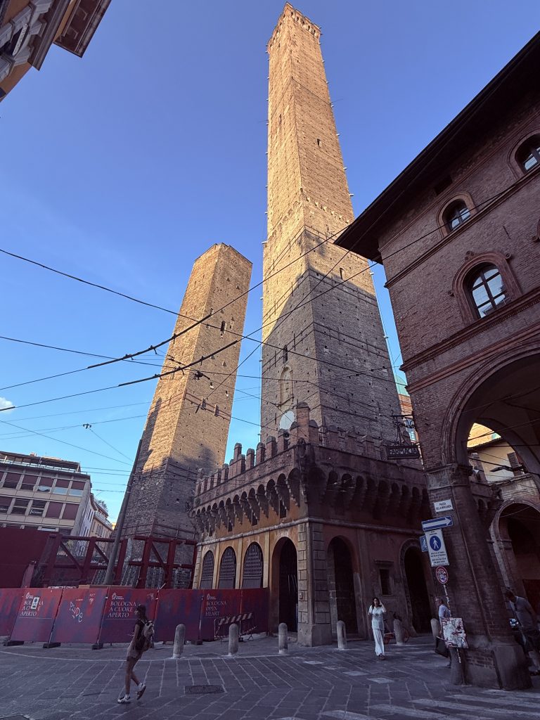 Las Torres de Bolonia por Jose Cotino Vista de las dos torres medievales de Bolonia, la Torre Asinelli y la Torre Garisenda, con cielo azul de fondo