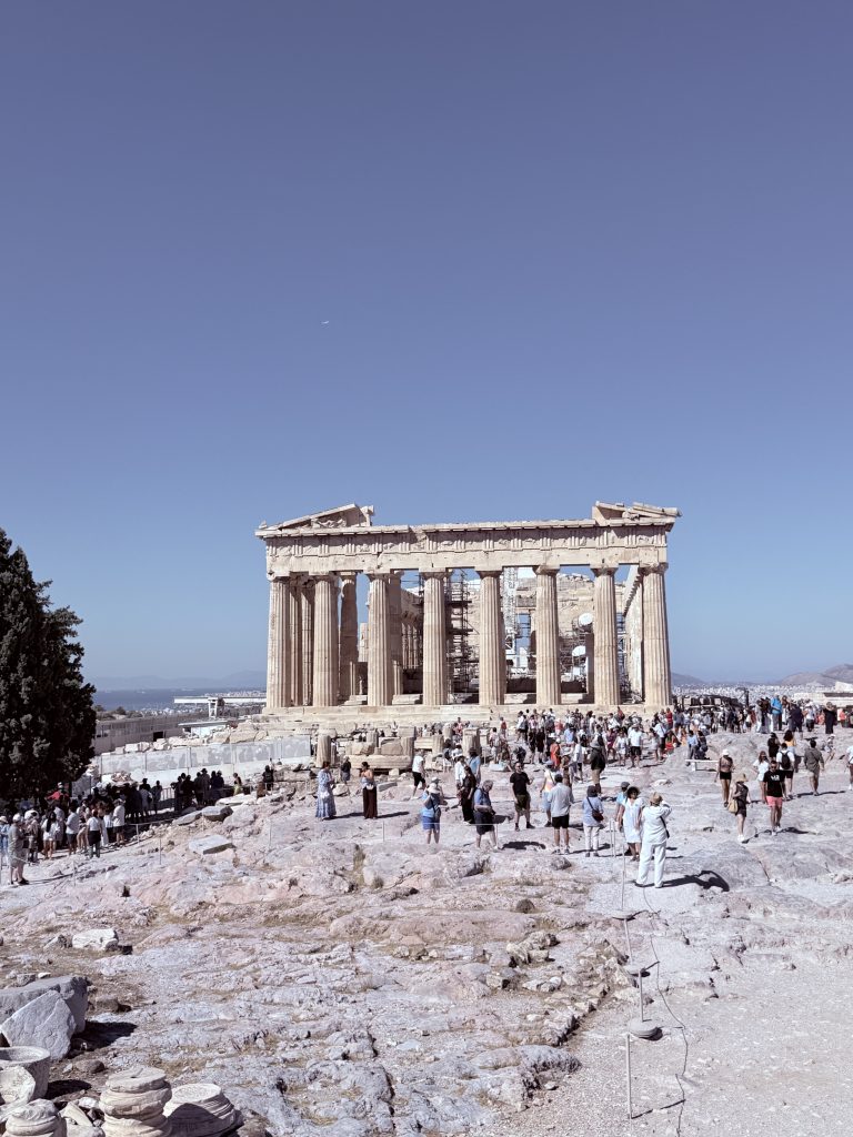 Vista del Partenón de Atenas rodeado de turistas durante un día caluroso de verano