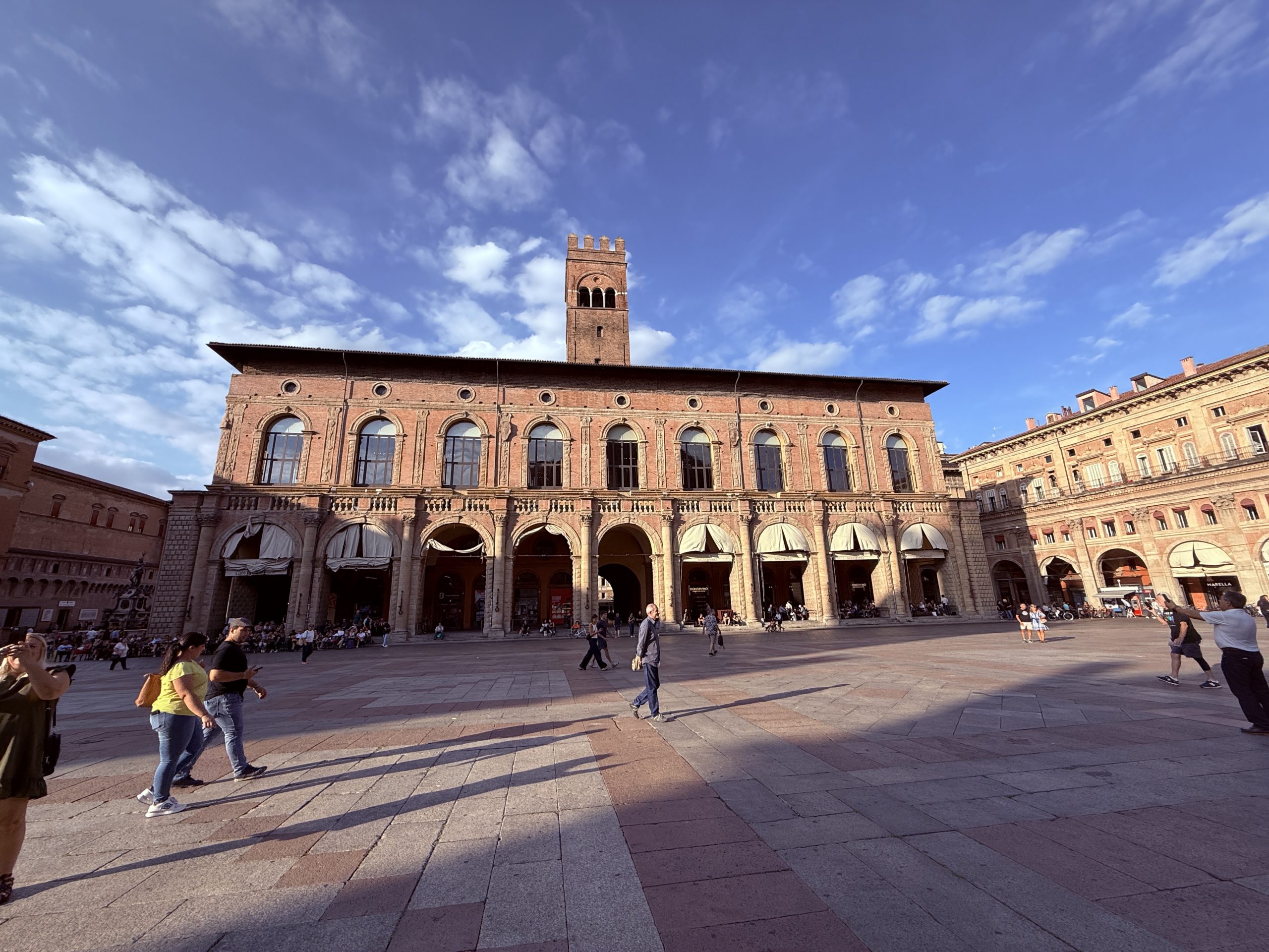 Vista panorámica de la Piazza Maggiore de Bolonia con la Basílica de San Petronio y gente paseando