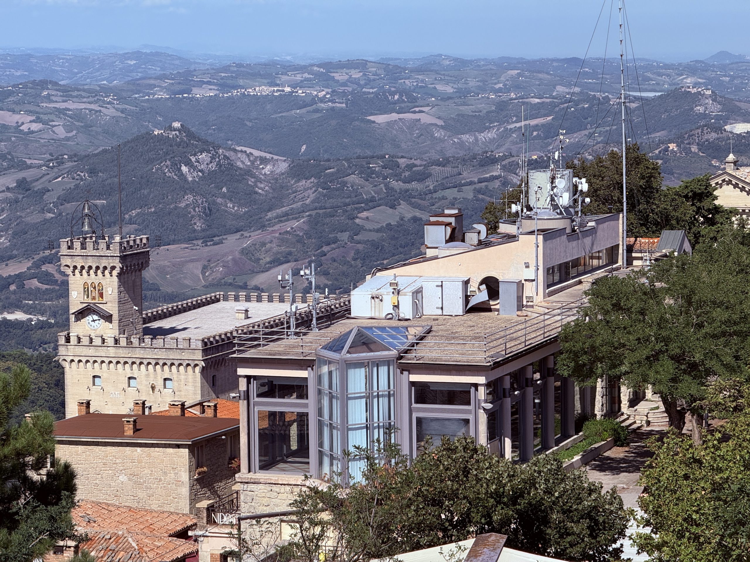 Vista panorámica desde la Torre Guaita en San Marino, con el Palacio Público en primer plano y las montañas al fondo