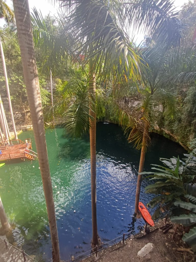 Cenote Saamal en Yucatán, con cascada en el centro y rodeado de paredes circulares de piedra caliza, ideal para nadar