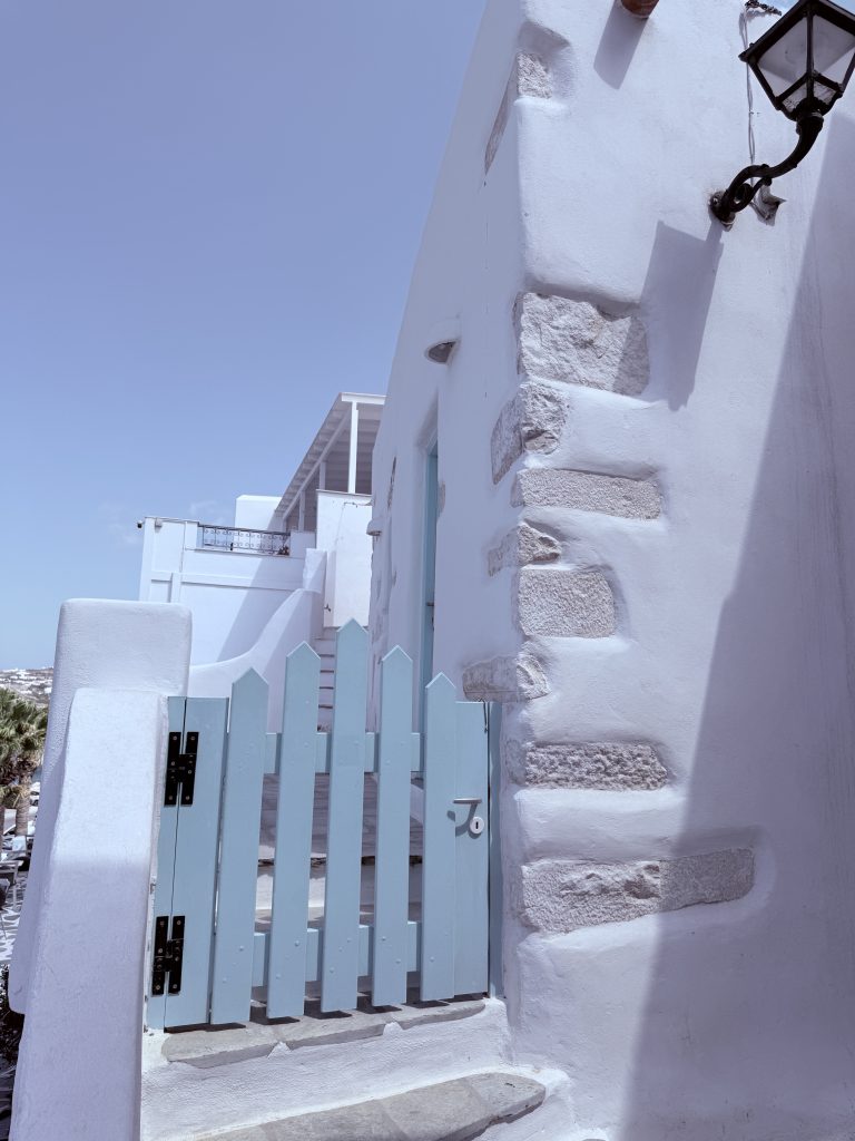 Casa tradicional en Paros con fachada blanca, escalera exterior y puerta azul decorada
